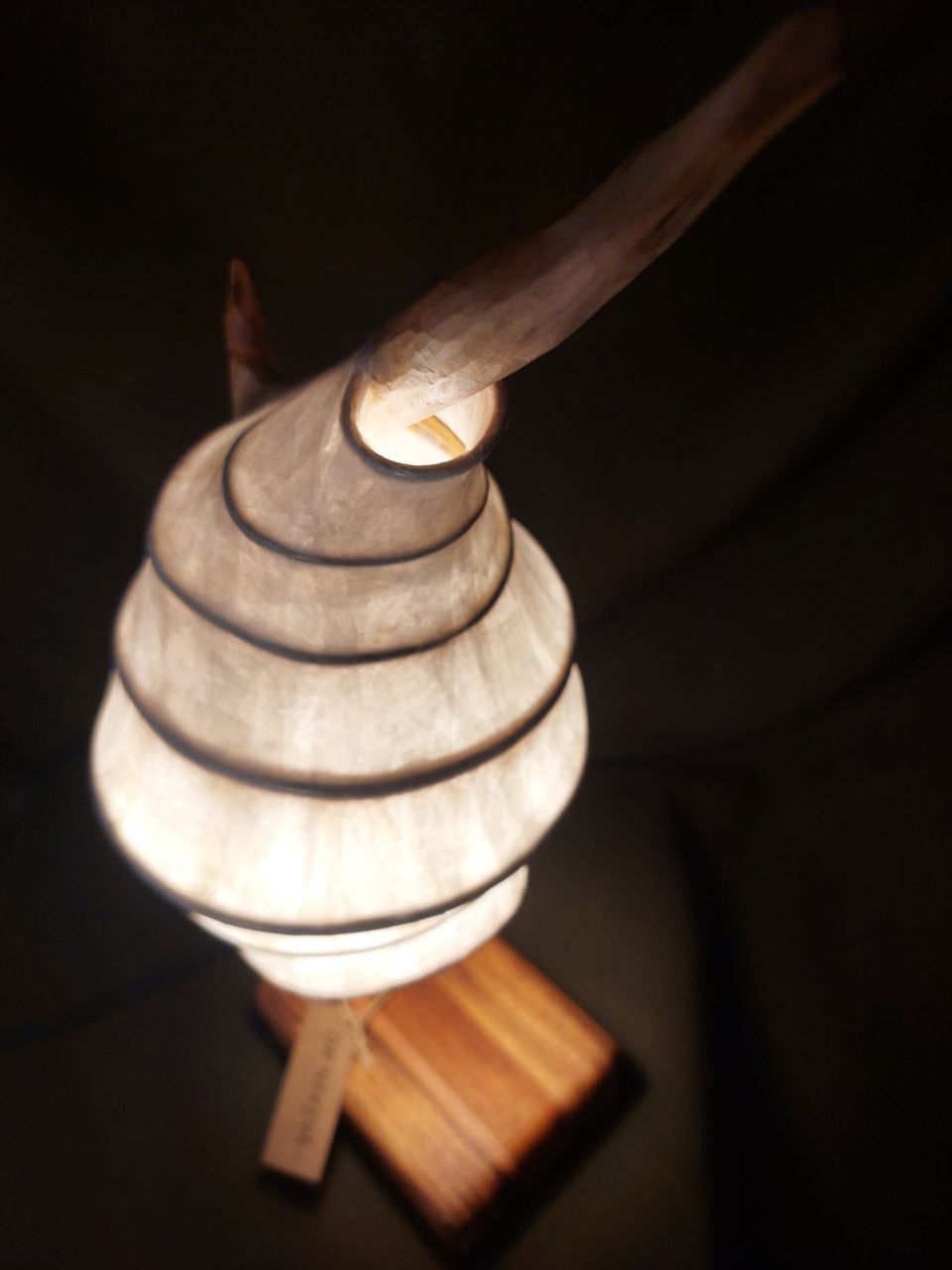 Capullo: luminaria de papel en espiral ascendente coronada por una rama de madera